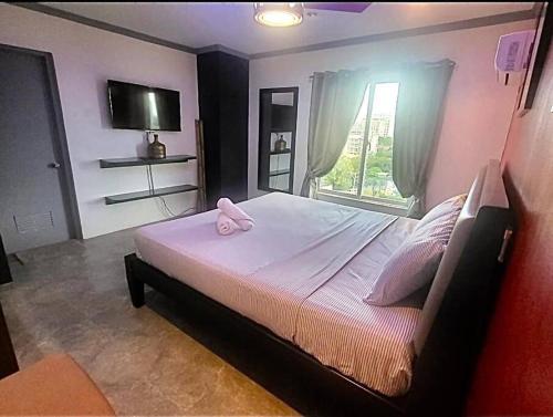 um quarto com uma cama com chinelos cor-de-rosa em Kandi Modern 1BR, king bed. Wi-Fi, housekeeping! em Angeles