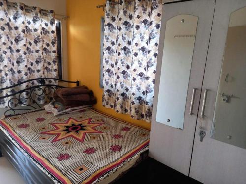 a small bedroom with a bed and a window at Om Sai Guest House in Nashik
