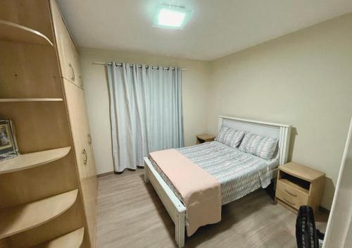 niewielka sypialnia z łóżkiem i oknem w obiekcie Apartamento Florianópolis w mieście Florianópolis