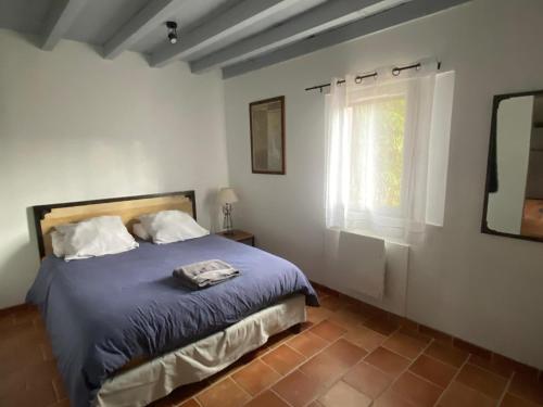 1 dormitorio con cama y ventana en gite " ploum" en Pouydesseaux