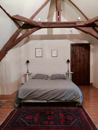 - une chambre avec un grand lit et 2 tables dans l'établissement La Maillardière - Maison de campagne avec piscine, à Corné