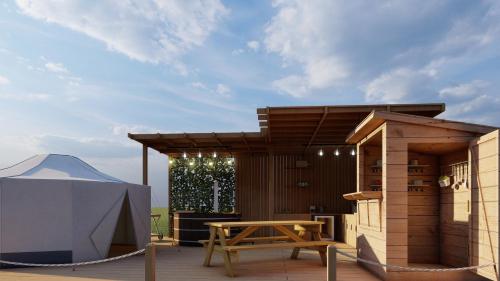 a patio with a wooden table and a tent at Dukeries Retreat in Retford