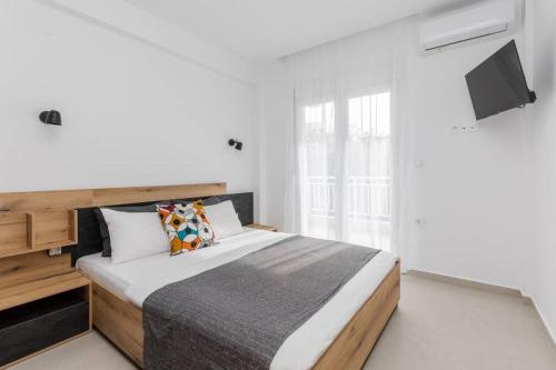 a bedroom with a bed and a tv on the wall at MS Homes Peraia 1 in Perea