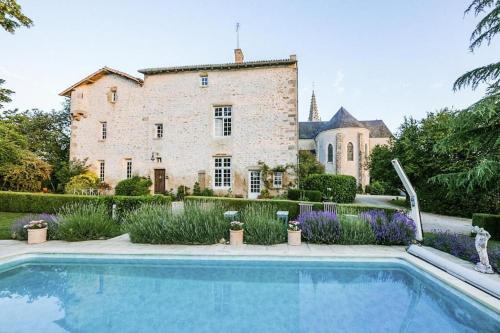 a house with a swimming pool in front of a building at 14th Century Priory in Pressigny in Pressigny