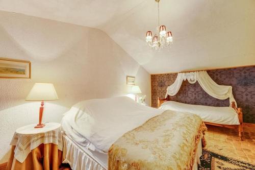 a bedroom with a bed and a table with a lamp at 14th Century Priory in Pressigny in Pressigny