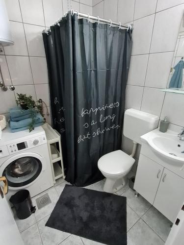 a bathroom with a toilet and a shower curtain at Jenny's Place Sarajevo in Sarajevo