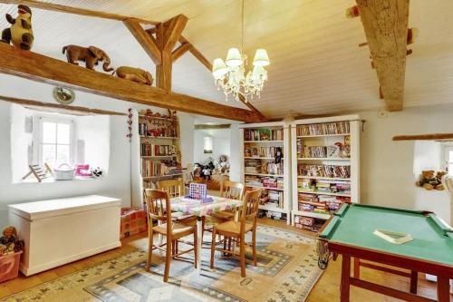a dining room with a table and a pool table at 14th Century Priory in Pressigny in Pressigny