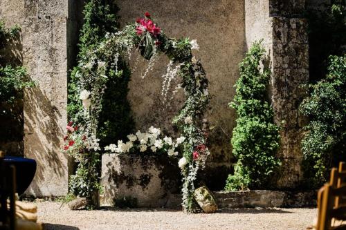 a wedding arch with flowers and roses at 14th Century Priory in Pressigny in Pressigny