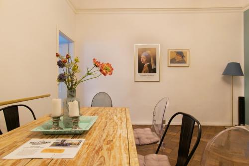 a dining room table with a vase of flowers on it at Cozy Apartments Krakowska Street, Kazimierz District in Krakow