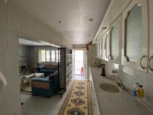 a bathroom with a sink and a living room at Kuzey’s home in İzmir