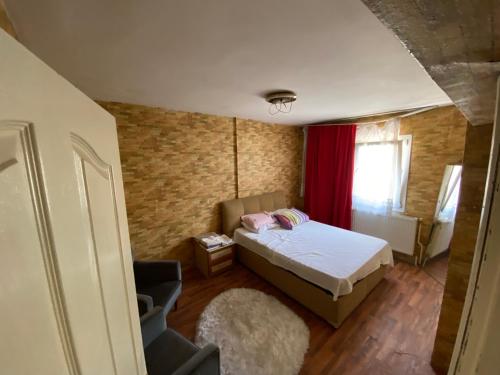 um pequeno quarto com uma cama e uma cortina vermelha em Kuzey’s home em Esmirna