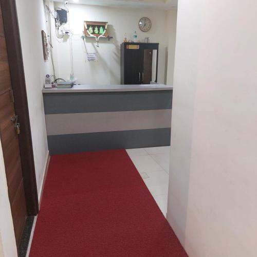 a hallway with a red carpet and a refrigerator at Swastik lodge in Belgaum