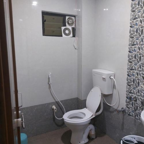 a bathroom with a toilet and a shower at Swastik lodge in Belgaum