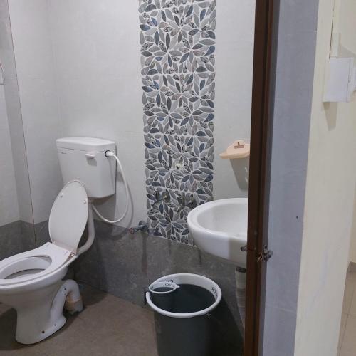 La salle de bains est pourvue de toilettes et d'un lavabo. dans l'établissement Swastik lodge, à Belgaum