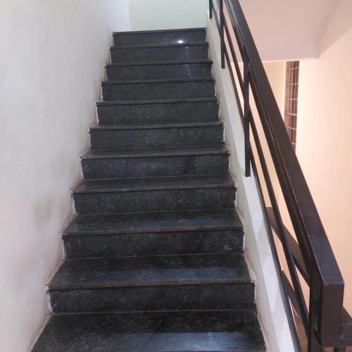 a set of stairs in a house with black railings at Swastik lodge in Belgaum