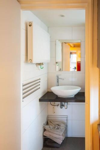 a white bathroom with a sink and a mirror at De Kapelle in Oudewater in Oudewater
