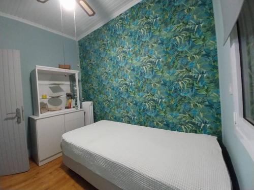 a bedroom with a bed and a blue wall at Fairytale στις Αλυκές Χαλκίδας in Chalkida