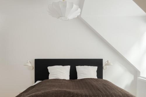 a bedroom with a bed with a black headboard at Central City Flats on Best Location by Round Tower in Copenhagen