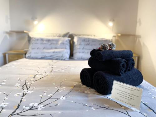 una pila de toallas sentadas encima de una cama en Ca al Borgo - Lago di Como, en Faggeto Lario 
