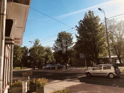 un coche aparcado en un estacionamiento al lado de una calle en Jenny's Place Sarajevo, en Sarajevo