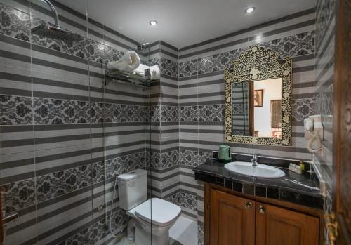 uma casa de banho com um lavatório, um WC e um espelho. em Darif's Riad & Spa em Fez
