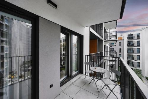 ein Balkon mit Tisch und Stühlen auf einem Gebäude in der Unterkunft Golden Dreams Luxury Apartments 21 in Krakau