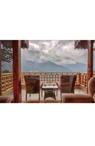 Blick auf eine Terrasse mit Stühlen und einem Tisch in der Unterkunft Staynest Gangtok with balcony view in Gangtok