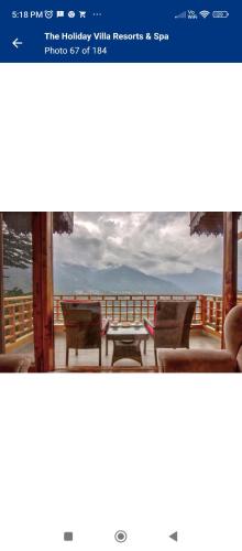 Blick auf eine Terrasse mit einem Tisch und Stühlen in der Unterkunft Staynest Gangtok with balcony view in Gangtok