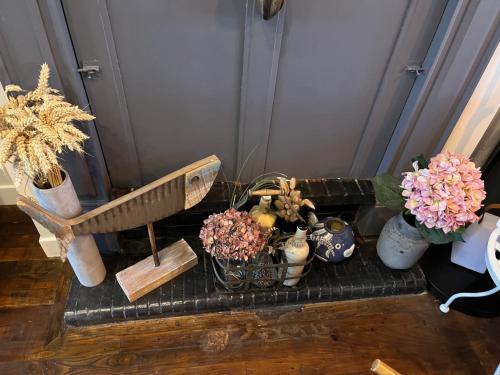 een tafel met bloemen en andere items erop bij Villa Noroit in Cherrueix