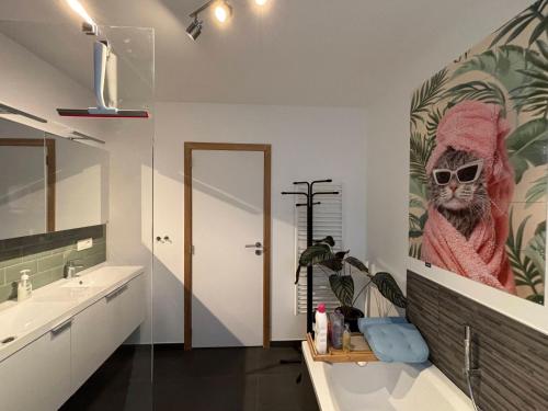 a bathroom with a monkey painting on the wall at Maison Seigneur in Asse