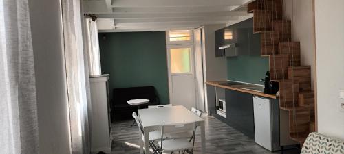 une petite cuisine avec une table blanche, une table et des chaises dans l'établissement Maison de ville - vue sur la Sainte Baume, à Aubagne