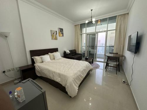 a bedroom with a bed and a couch and a television at Cozy Private Studio APT in Al Mamzar Sharjah in Sharjah