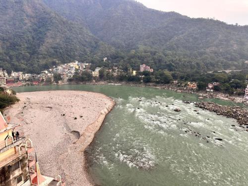 a view of a river with mountains in the background at Yoga Retreat at The Ganges in Rishikesh in Rishīkesh