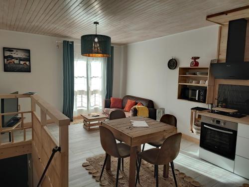 a kitchen and living room with a table and chairs at Appartement Chez Marie et Aymeric in Bages