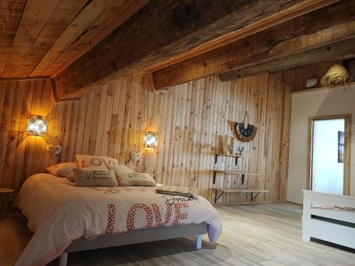 a bedroom with wooden walls and a bed in a room at Appartement Chez Marie et Aymeric in Bages