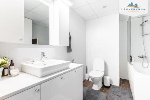 a white bathroom with a sink and a toilet at Romantiline Haapsalu ootab Sind in Haapsalu