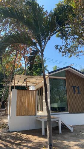 a small house with a palm tree in front of it at Tree nara garden houes kohlarn in Ko Larn
