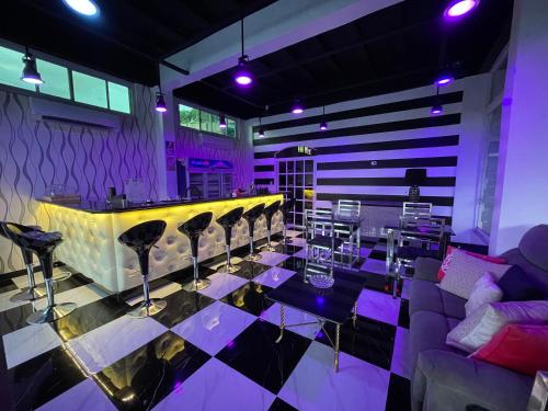 a room with a bar with chairs and purple lighting at Italy Condotel Darasa in Tanauan
