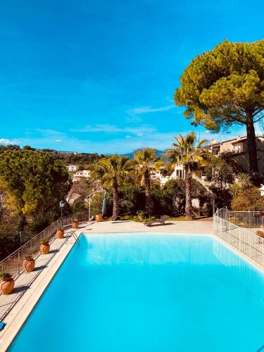 une piscine avec des palmiers et un ciel bleu dans l'établissement Villa sur le toit, duplex, 5 pièces 160m2, piscine, à Villeneuve-Loubet