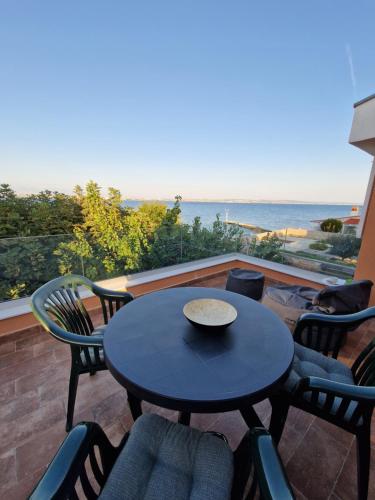 a patio with a table and chairs and the ocean at Casa Luma in Poljana