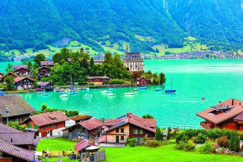 a view of a village with boats in the water at Chalet Swiss Alpine Haven in Iseltwald