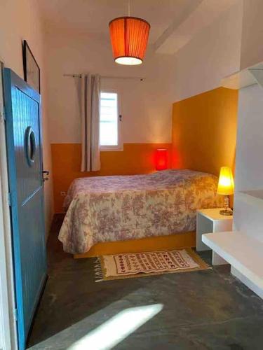 a small bedroom with a bed and a window at Dar Dielna in Oualidia