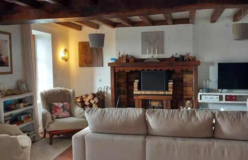 a living room with a couch and a fireplace at La Tour du Boueix in Préveranges
