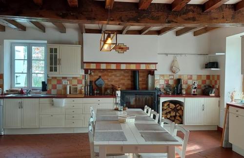 eine Küche mit einem Tisch und Stühlen in der Unterkunft La Tour du Boueix in Préveranges