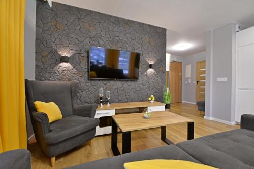 a living room with a tv on a wall at Sun Towers - Apartamenty Bryza - Apartamenty z parkingiem in Świnoujście