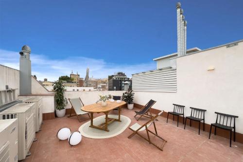 een patio met een tafel en stoelen op een dak bij Rustic Style Apartments & Studios BCN in Barcelona