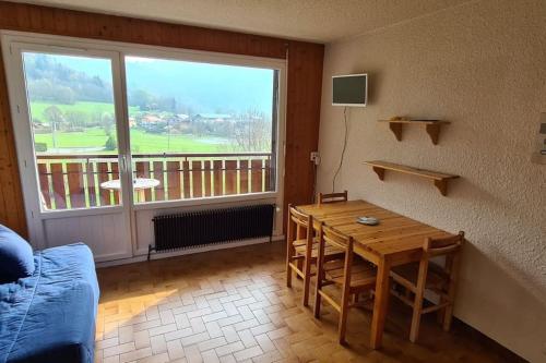 un salon avec une table et une grande fenêtre dans l'établissement Studio cabine au cœur de la montagne Les Memises, à Thollon-les-Mémises