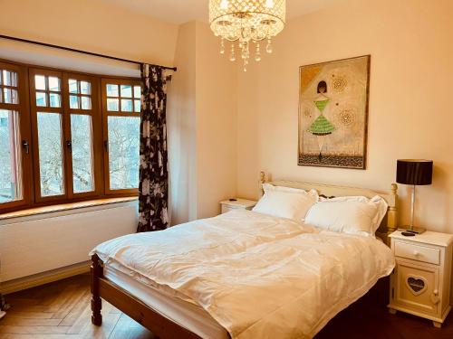 Un dormitorio con una cama grande y una lámpara de araña. en Georgian Guest Rooms en Basilea