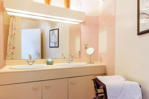 ein Badezimmer mit zwei Waschbecken und einem großen Spiegel in der Unterkunft Charmant 3P. Calme, spacieux et lumineux. 90 m2 in Paris