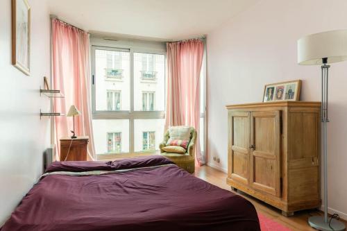 sypialnia z łóżkiem, krzesłem i oknem w obiekcie Charmant 3P. Calme, spacieux et lumineux. 90 m2 w Paryżu